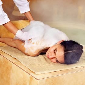 Young woman in hammam or turkish bath. Steam in bathroom.